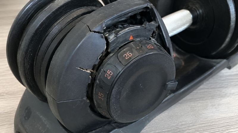 Broken or worn adjustable dumbbell mechanism showing why cheap dumbbells fail